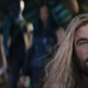 Thor looking lovingly at a figure with their back to us while onlookers watch